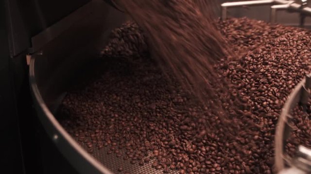 Opening a coffee roasting machine with fresh roasted coffee beans