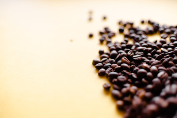 Roasted coffee grains and takeaway cup top view. Craft paper tea cup on orange background flat lay. Cafe web banner with copyspace