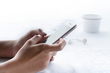 woman hang holding cellphone in morning breakfast with earphone and cup of coffee on white background