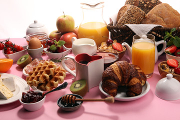 Huge healthy breakfast on table with coffee, orange juice, fruits, waffles and croissants. Good morning concept.