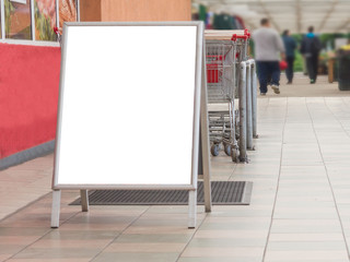 Blank billboard in a supermarket, next to shopping carts
