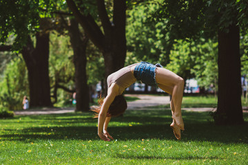 Freedom concept. Happy woman does tricks and jumps in city park, nice girl with good mood having fun, lifestyle 