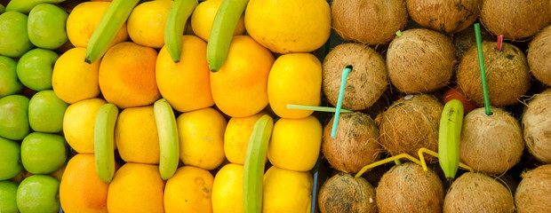 Exotic fruits on the counter (orange, coconut, watermelon, banana, apple, pineapple)