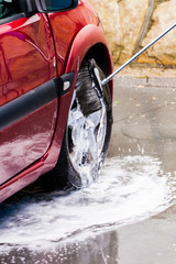 manual car washing with pressurized water and soap in car wash outdoor