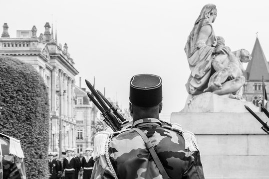 Black ethnicity soldier at ceremony to mark Western allies World War Two victory Armistice in Europe paying tribute in front of Monument aux morts de Strasbourg monochrome image