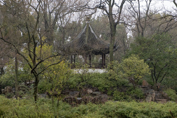 China, Suzhou, Humble Government Park pavilion with red wood columns and black roof on the hill with stairs