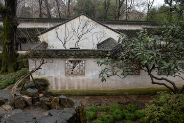 China, Suzhou, Humble Government Park garden white wall with black china style roof, with decorative window