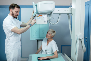 Obraz premium Male radiologist taking X-ray of patients hand in the hospital.