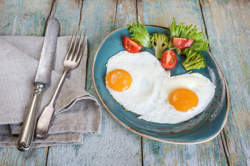 Two fried eggs and vegetables