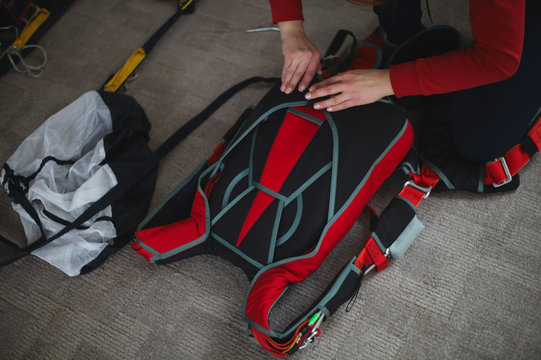 Woman Rigger Is Packing Parashute Before Jumping In The Aerodrome Room Close-up. Face Is Not Visible. Parachute Equipment.