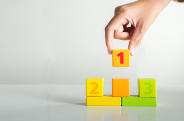Hand woman select wood block 1 on white background,Concept of number one and top winner success