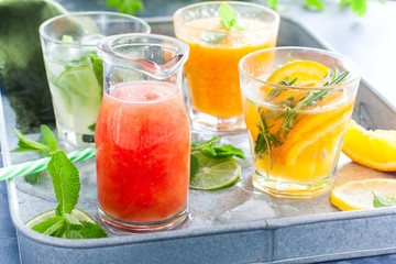 Assorted summer cold citrus drinks on a metal tray, horizontal