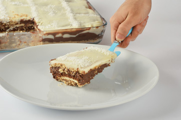 A male hand serving piece of homemade cake