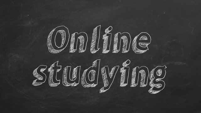 Hand drawing "Online studying" on black chalkboard. Stop motion animation.