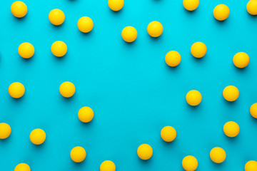 many balls for table tennis on turquoise blue background. flat lay image of many table tennis balls...