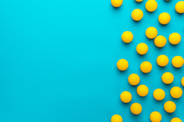 many balls for table tennis on turquoise blue background. flat lay image of many yellow table...