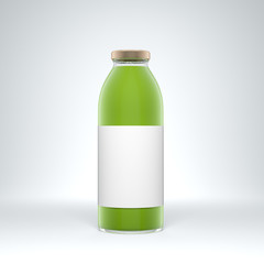 Tall transparent glass bottle with label filled by vegetable juice on the white background.