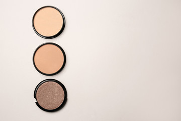 Different facial powder on light background