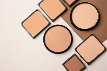 Different facial powder on light background