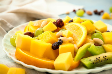 Plate with tasty mango salad on table, closeup