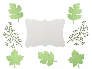 Green leaves and branches with grey copy space on white background. Greeting card concept