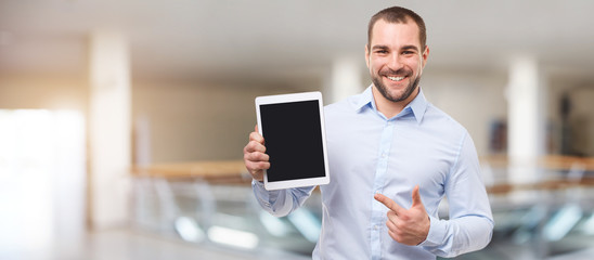 Happy man in the business center with tablet