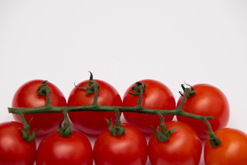 Cherry tomatoes on branch isolated on white background. Top view.
