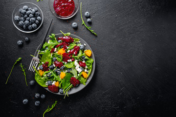Summer salad with salad leaves, fruits, berries and cheese