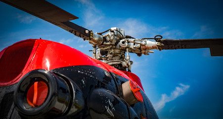 red and black helicopter standing at the airfield motor close up