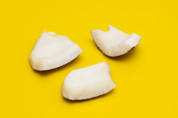 Slices of coconut pulp on a colored background. Refreshing Coconut
