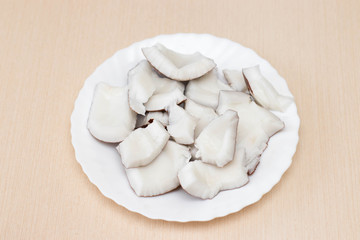 Coconut sliced on a plate. On the table is a plate of coconut slices.