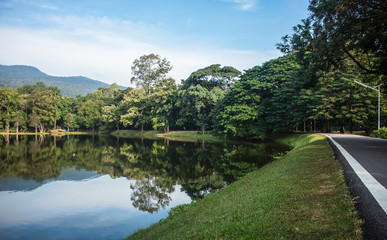 Fototapeta premium Amazing view of the Ang Kaew Reservoir lake, surrounded by trees and mountain in the background. Chiang Mai, Thailand.