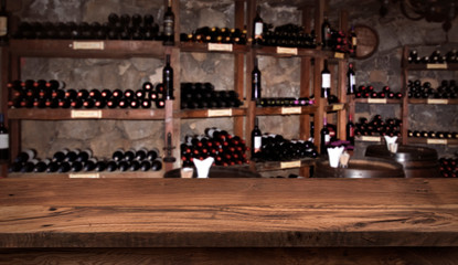 Wine sampling concept. Wooden board before defocused shelfs and barrels