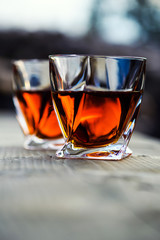 shot of whiskey at sunset dramatic sky on mountain landscape background