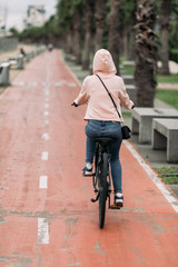 woman cyclist riding a bike on bike path on the embankment