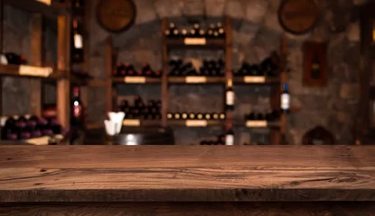  Defocused dark wine cellar background with wooden table in front © didecs