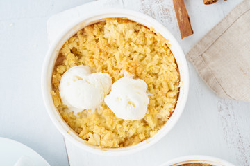 Apple crumble with ice cream, streusel. Morning breakfast on a light gray table. Top view, close up