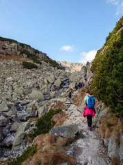 Fototapeta premium Hikers on trail at Great Cold Valley, Vysoke Tatry (High Tatras), Slovakia. The Great Cold Valley is 7 km long valley, very attractive for tourists