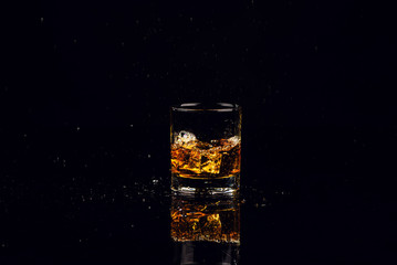 Isolated shot of whiskey with splash on black background