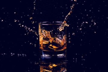 Isolated shot of whiskey with splash on black background