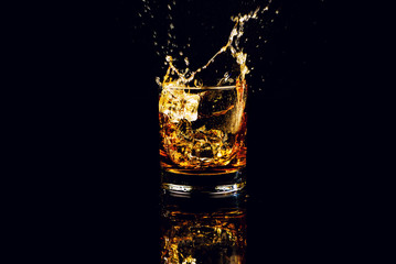 Isolated shot of whiskey with splash on black background