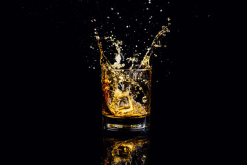 Isolated shot of whiskey with splash on black background