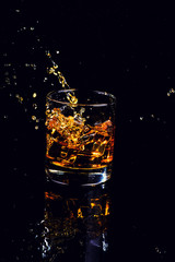 Isolated shot of whiskey with splash on black background