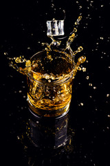 Isolated shot of whiskey with splash on black background