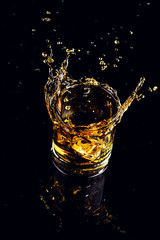 Isolated shot of whiskey with splash on black background