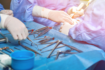 Close up of doctor hands during surgery in operation room. Sterile surgery instruments used in a...