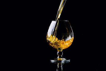 glass with cognac on a black background