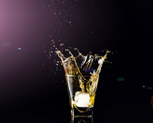 Isolated shot of whiskey with splash on black background, brandy in a glass