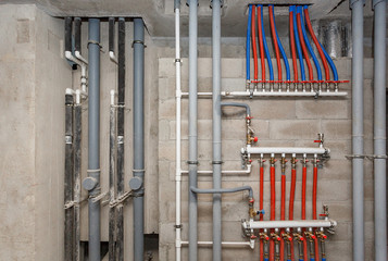 Pipes of heating and water supply system on the background of a concrete wall.