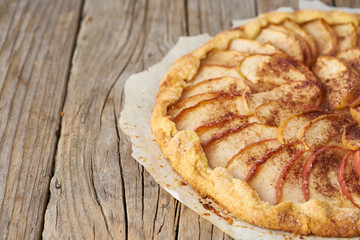 Apple pie, galette with a fruits, sweet pastries on old wooden rustic table, side view, copy space.